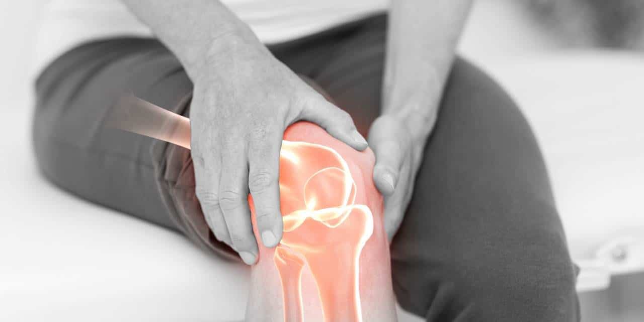 man holding knee with pain